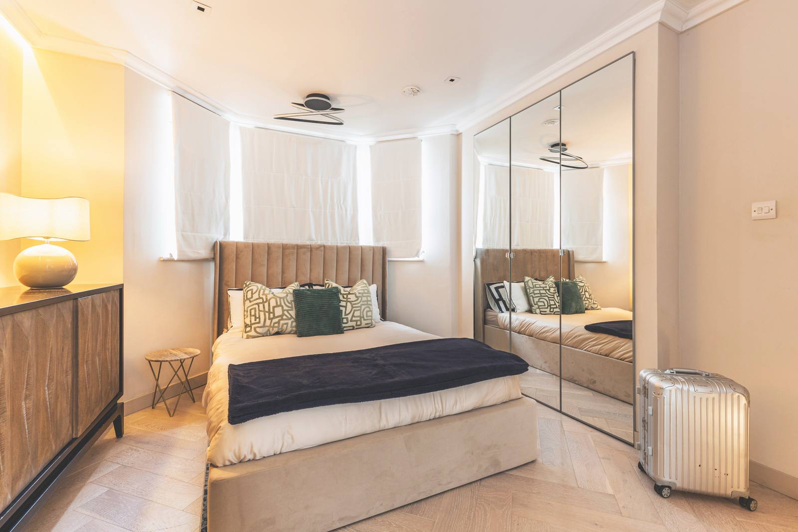 Bedroom one with a double bed, bedside lamp and mirrored wardrobes